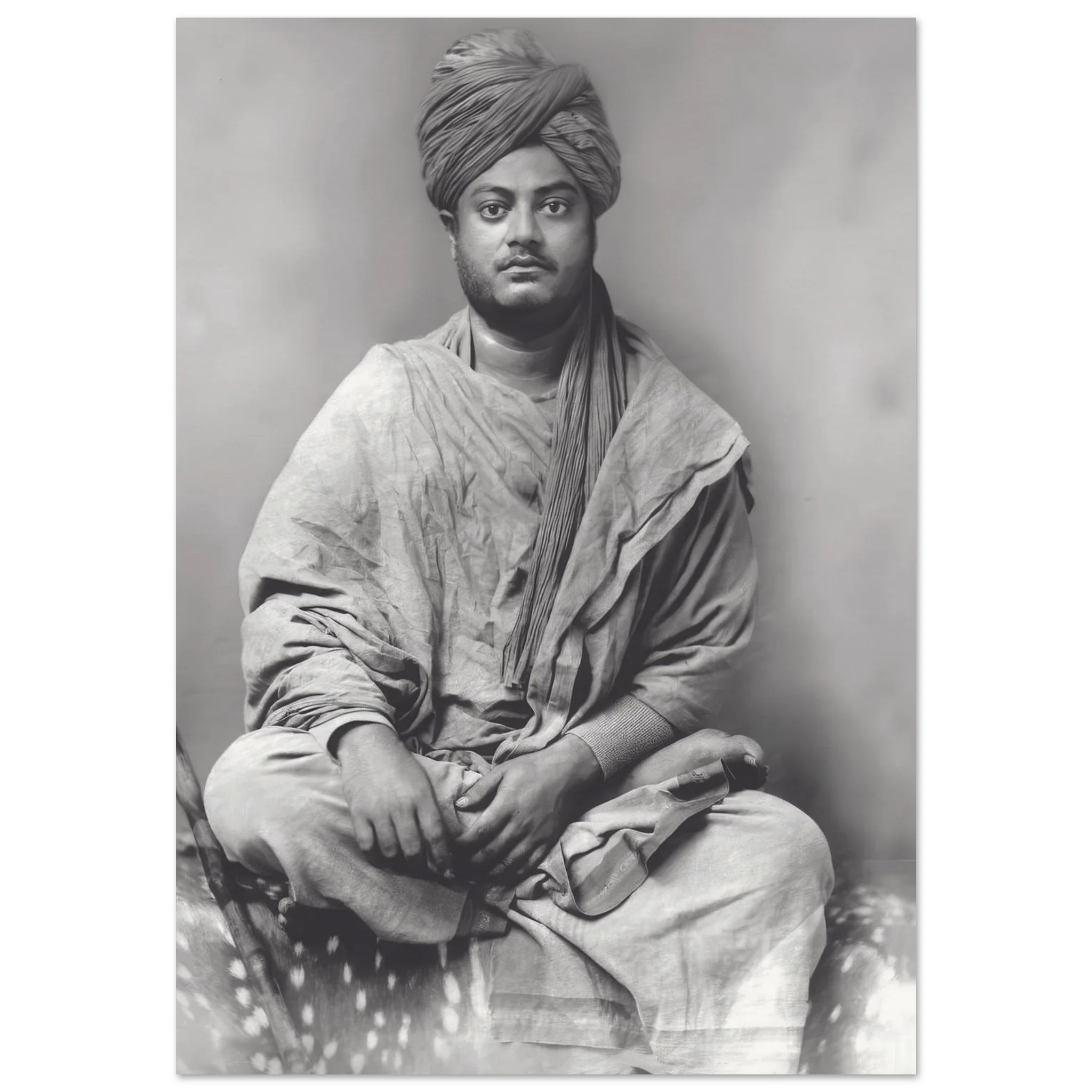 Black-and-white photograph of Swami Vivekananda seated cross-legged, clad in robes and turban