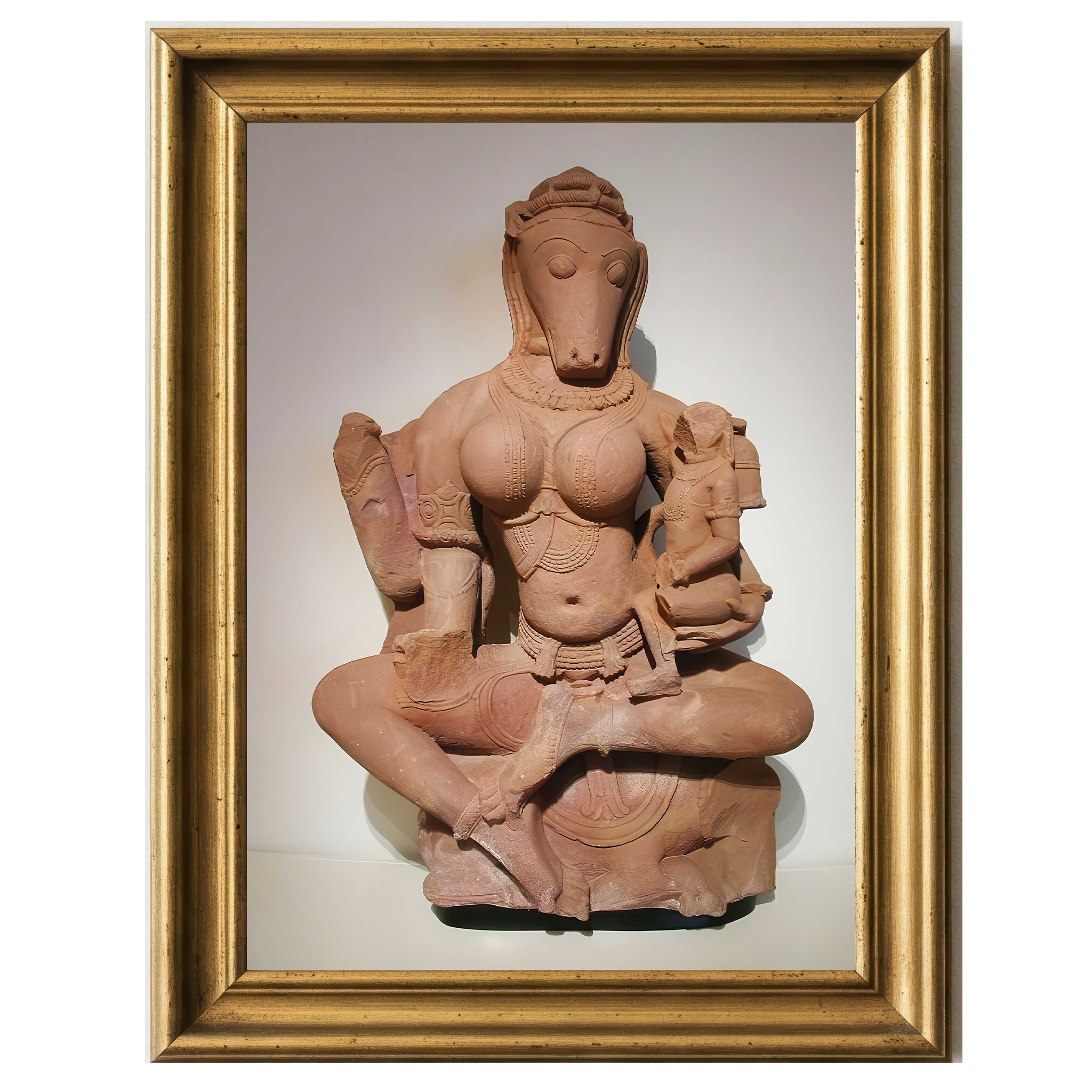Sandstone sculpture of horse-headed Yogini Hayagriva seated cross-legged and holding a child