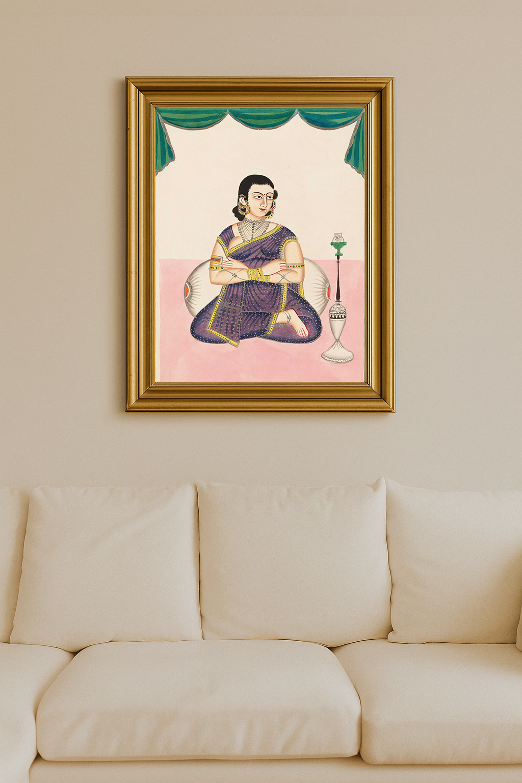Indian woman in purple sari seated cross-legged with folded arms, adorned in jewelry, beside a traditional hookah, under ceremonial green drapery.